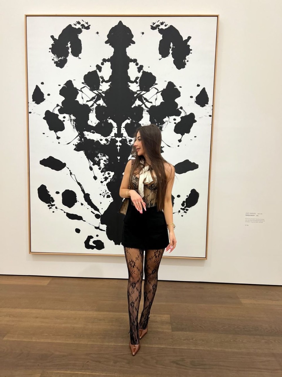 Liliia Shchepkiv, founder of SVOYA, in a gallery in front of an Andy Warhol Rorschach painting
